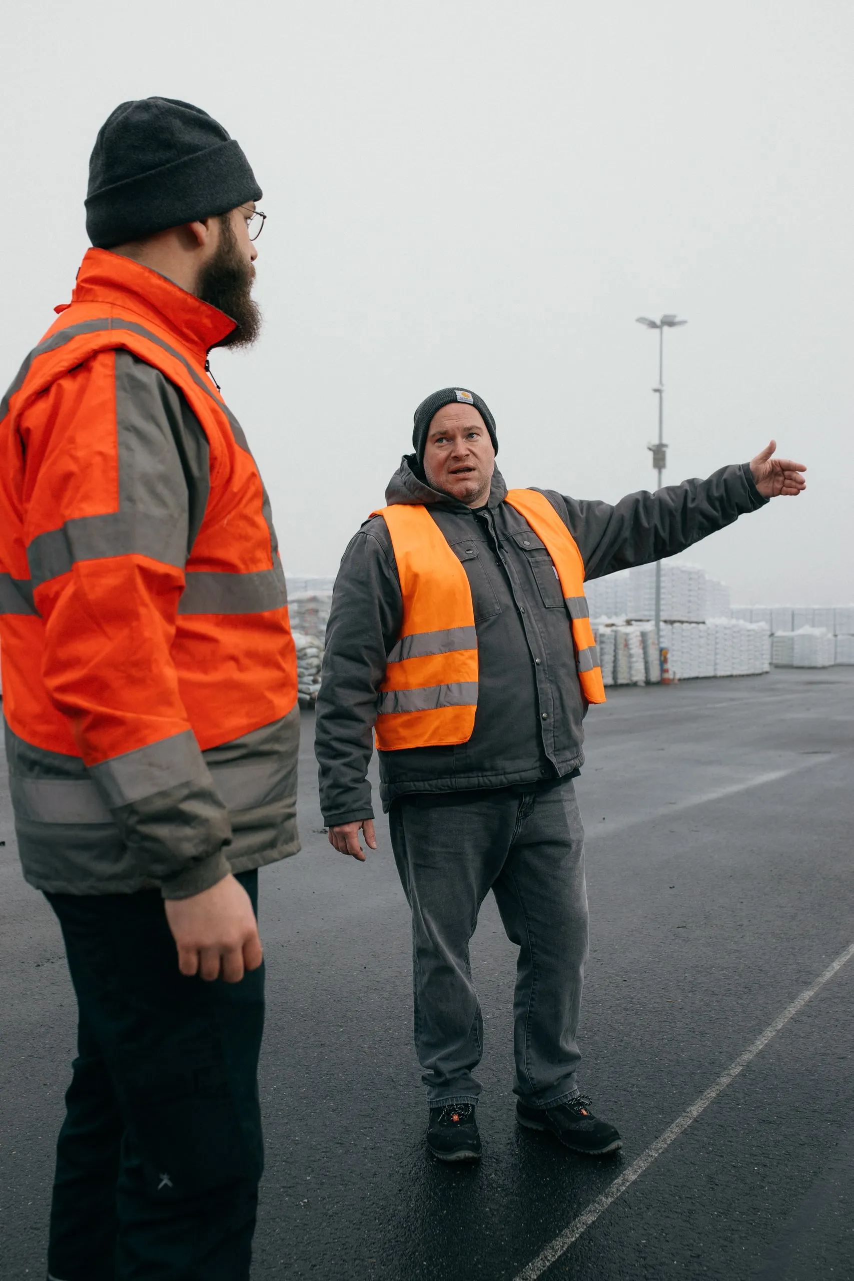 Zwei Mitarbeiter in Warnwesten im Gespräch auf dem Gelände der Presto Gruppe