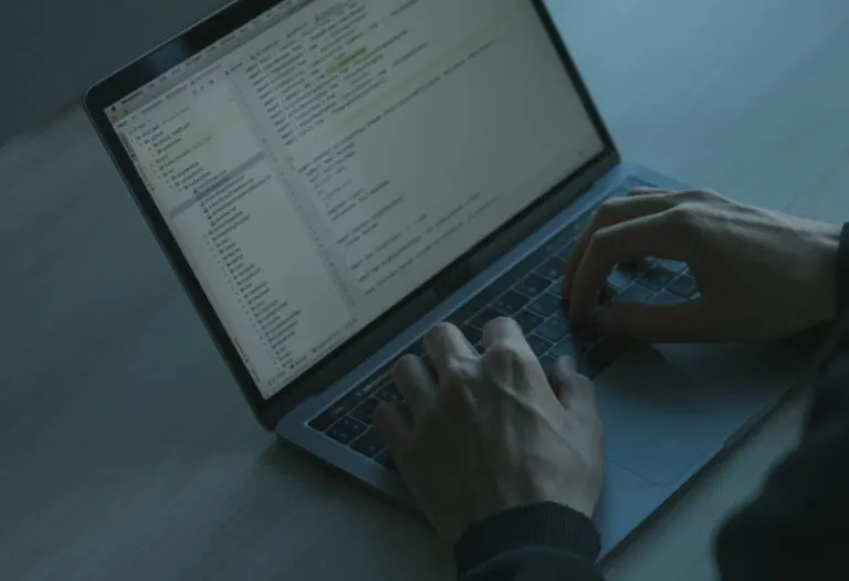 Hände an einem Laptop, auf dem Bildschirm eine Konfigurationsübersicht mit Dateibaum