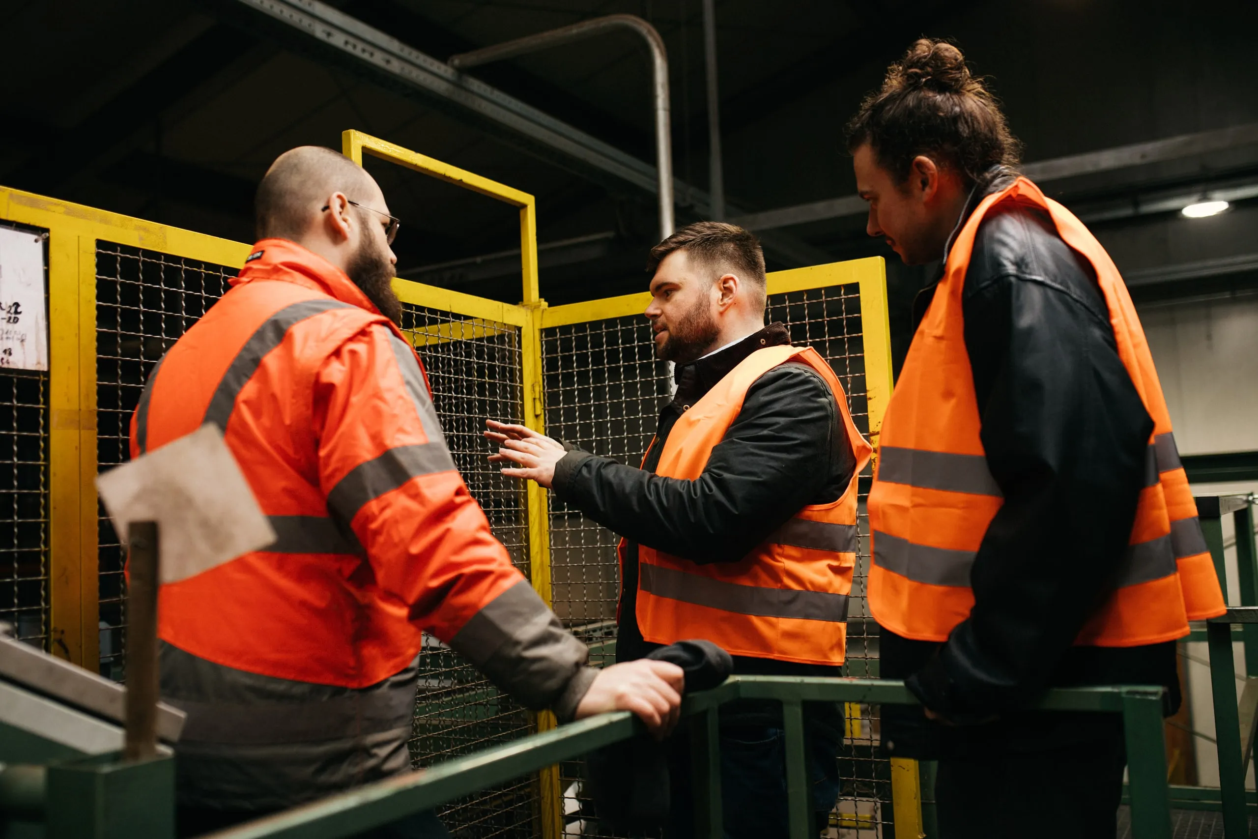 Drei Personen besprechen eine Anlage im Werk von Presto Humus