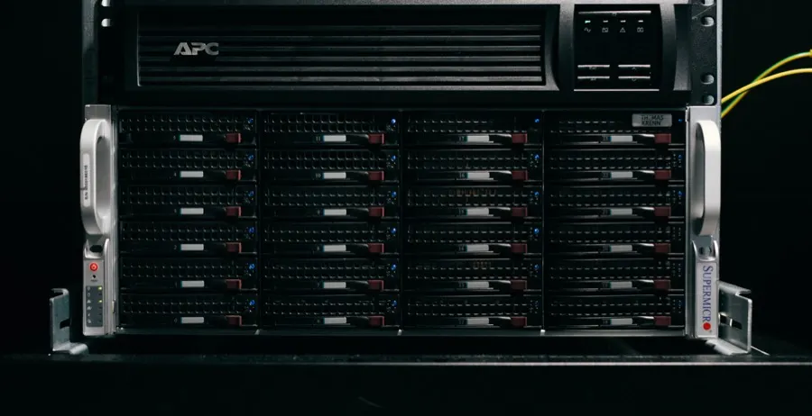 Server chassis with 24 drives in a rack, an uninterruptible power supply above it