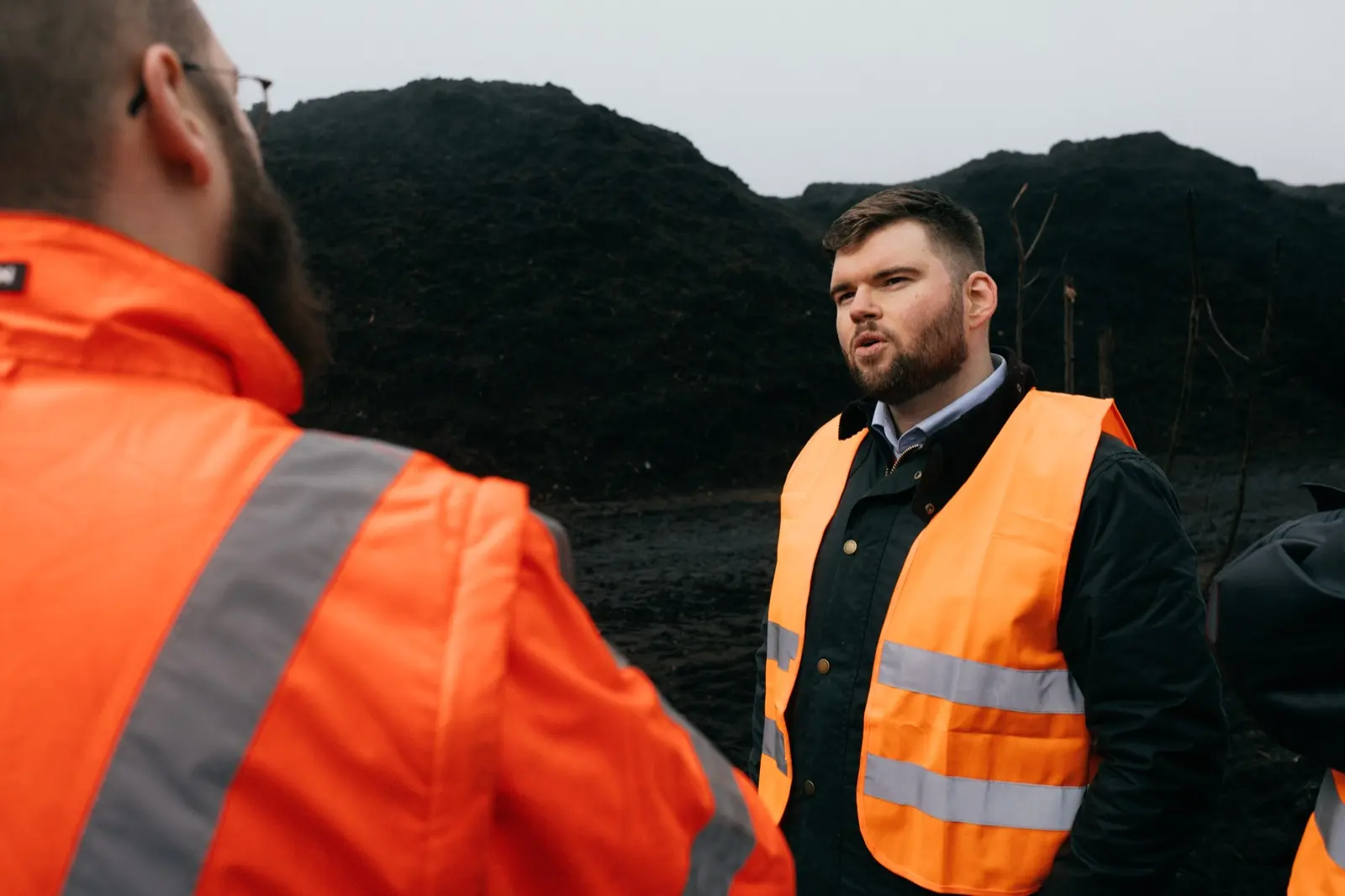 Two Sysfacts staff in high-visibility vests talking on a company site